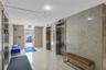 Lobby area featuring full-height natural stone wall cladding, polished stone flooring, and dual stainless steel elevator doors