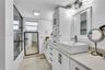 Bathroom featuring dual rectangular vessel sinks, stone-finish countertops, and a walk-in shower with a framed glass enclosure