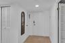 Foyer featuring neutral tile flooring, recessed lighting, and white louvered closet doors