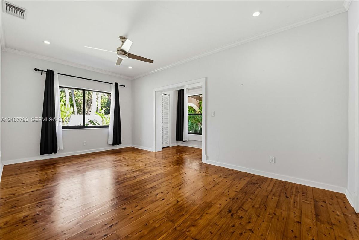 Room featuring wood-finish flooring, recessed lighting, and a multi-blade ceiling fan