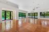 Open-concept interior featuring large-format ceramic tile flooring, multi-panel sliding glass doors, recessed lighting, and a wall-mounted climate con
