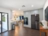 Kitchen featuring full-height light gray cabinetry, built-in stainless steel double wall ovens, a multi-door refrigerator, a center island, and wood-f