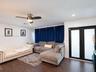 Wood-finish flooring, brushed metal ceiling fan with integrated lighting, and black-framed double doors with frosted glass panels