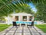 Outdoor space featuring a swimming pool, concrete paver grid patio with stone inlay, covered patio area, and architectural columns