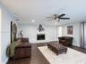 Living space featuring wood-finish flooring, a flush-mounted ceiling fan, recessed lighting, and a fireplace with a metallic surround