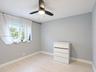 Neutral-toned walls, wood-finish flooring, and a modern ceiling fan with integrated lighting