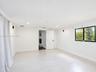 Neutral-toned space featuring light-colored wood-finish flooring, recessed lighting, and a window with a black frame
