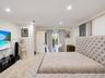 Recessed lighting, smooth walls, and sliding glass doors with gold-tone hardware