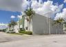 Concrete tilt-wall industrial building featuring a paved parking area, integrated roof-access ladder, and exterior landscaping
