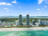 Aerial view featuring twin high-rise towers situated on a coastal beachfront with direct ocean access and proximity to local waterways