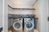 Laundry room featuring wood-finish countertop, dual-tier open shelving with mosaic tile backsplash, and recessed lighting