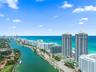 Aerial perspective featuring high-rise towers, proximity to the coastline, and a deep-water canal