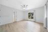 2nd Bedroom - Neutral-toned room featuring wood-finish flooring, a white ceiling fan with integrated lighting, and a large window