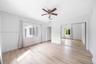 Wood-finish flooring, ceiling fan with integrated lighting, and sliding mirror-paneled closet doors