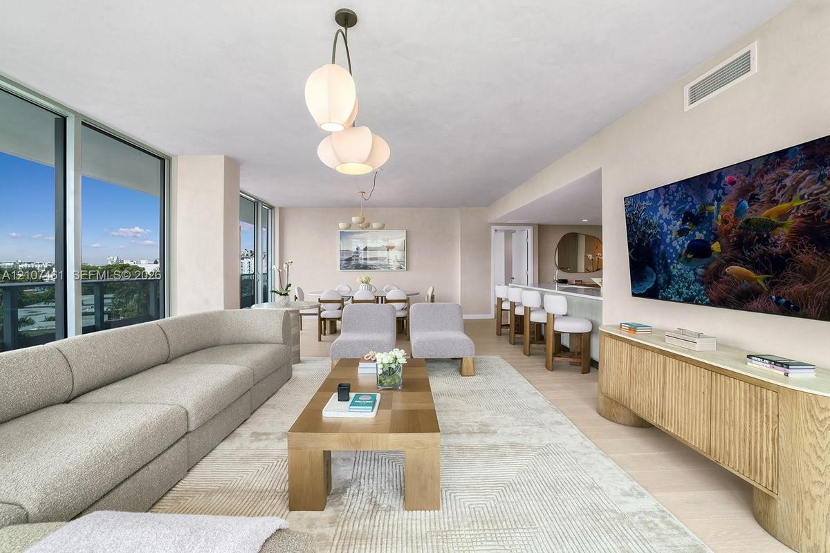 Floor-to-ceiling glass wall, light-toned wood-finish flooring, custom built-in cabinetry, and multi-tier sculptural pendant lighting