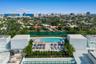 Rooftop swimming pool with paved decking and integrated landscaping, featuring a backdrop of coastal and urban scenery