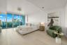 Floor-to-ceiling glass sliding doors, wood-finish flooring, and expansive balcony access featuring a metal railing
