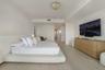 Spacious room featuring light-toned wood-finish flooring, recessed ceiling lighting, a sculpted semi-flush mount fixture, and smooth wall finishes