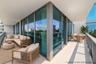 Wrap-around balcony featuring floor-to-ceiling glass paneling, metal railings, and concrete flooring