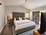 Vaulted ceilings, wood-finish flooring, and sliding glass doors with exterior access