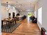 Vaulted ceilings, wood-finish flooring, kitchen island with stone countertop, recessed lighting, and geometric pendant fixtures