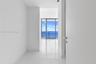 Polished stone flooring, floor-to-ceiling glass paneling, and expansive water scenery