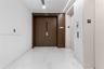 Entry foyer featuring white stone-finish flooring, double solid-core doors, and recessed linear ceiling lighting