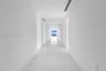Hallway featuring polished tile flooring, recessed ceiling lighting, and floor-to-ceiling windows