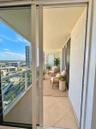 Covered balcony featuring tile flooring, a metal cable railing, and sliding glass door access