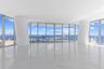 Floor-to-ceiling glass walls, expansive polished stone flooring, structural white columns, and wraparound balcony access