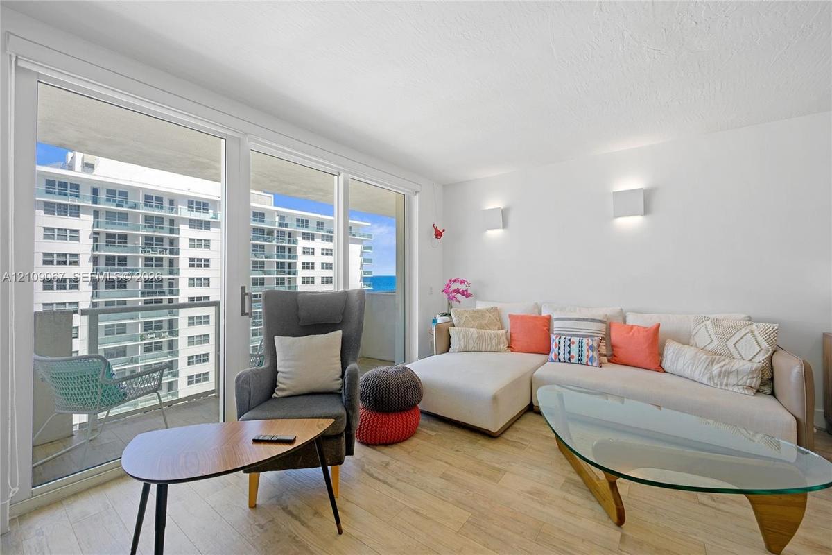 Floor-to-ceiling sliding glass doors, wood-finish flooring, and wall-mounted light fixtures