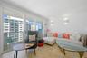 Floor-to-ceiling sliding glass doors, wood-finish flooring, and wall-mounted light fixtures