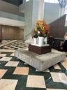 Grand foyer featuring geometric stone flooring in a contrasting diamond pattern, multi-level architectural design, and integrated panel wall detailing