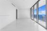 Interior space featuring floor-to-ceiling glass sliding doors, large-format tile flooring, recessed lighting, and a wrap-around balcony with glass rai