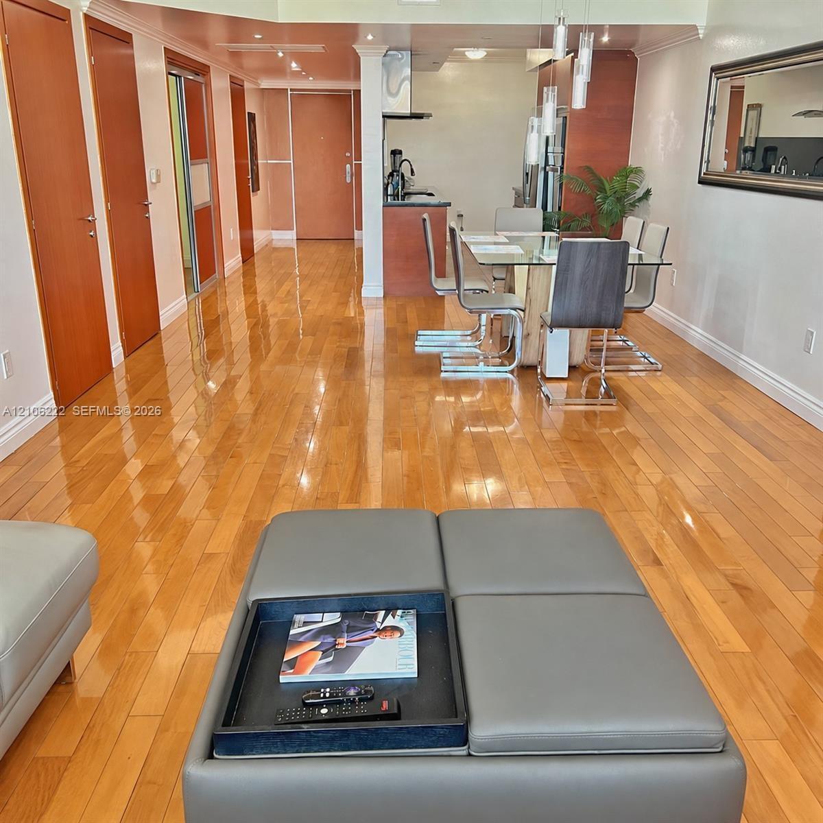Open concept interior featuring high-gloss wood-finish flooring, solid wood-paneled interior doors, and recessed lighting