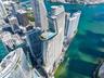 High-rise residential tower featuring a cantilevered pool deck, glass-paneled balconies, and architectural curvature situated at the waterfront