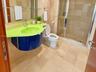 Floating vanity with a contoured countertop, wall-to-wall stone tile flooring, and walk-in shower with a glass enclosure