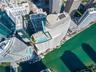 High-rise residential tower featuring a rooftop swimming pool, terrace, and water frontage