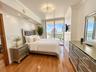 Wood-finish flooring, crown molding, recessed lighting, multi-bulb ceiling fixture, and floor-to-ceiling glass doors opening to a balcony