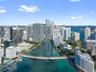 Aerial perspective featuring urban high-rise skyline, waterfront access, marina, and city bridge infrastructure