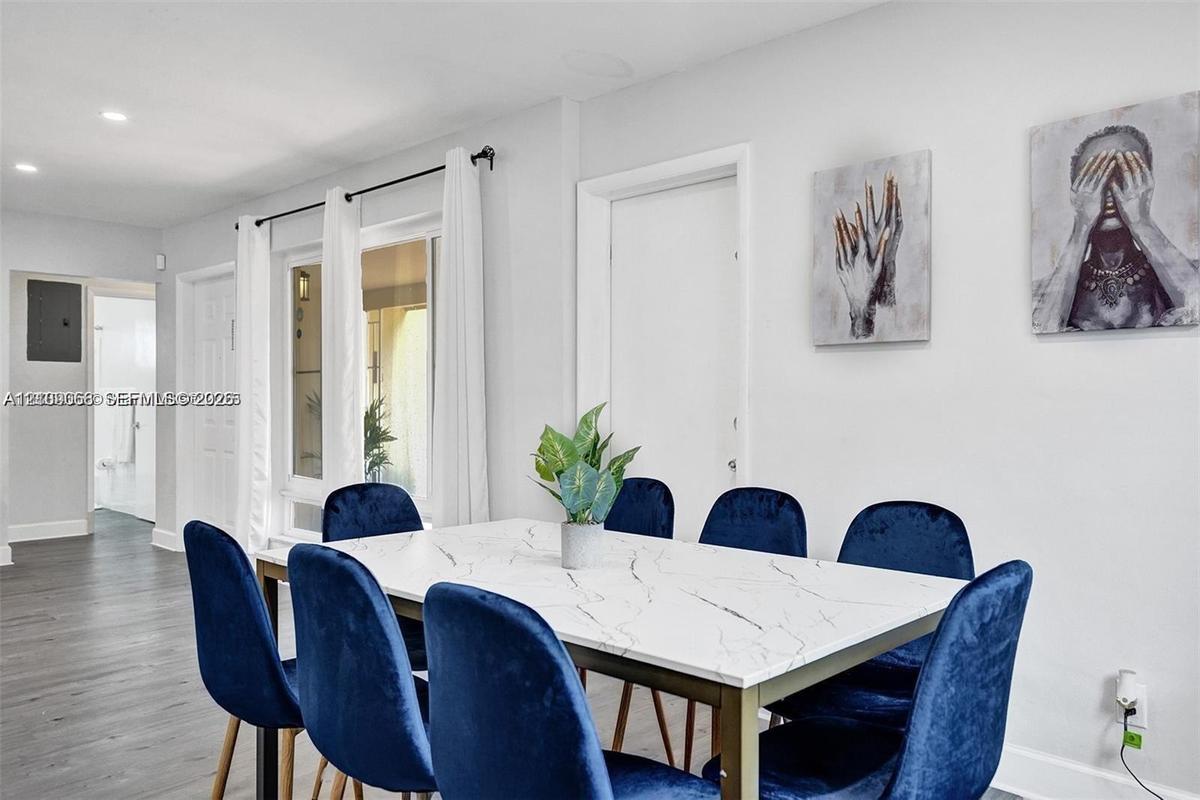 Neutral wall finishes, recessed lighting, wood-finish flooring, and large windows with integrated curtain rods