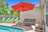 Backyard featuring a paver patio and a concrete-lined pool with a decorative tile border, enclosed by a wood privacy fence