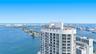 High-rise building featuring a curved architectural design, floor-to-ceiling glass windows, and private balconies overlooking the surrounding bay and 