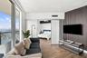 Floor-to-ceiling windows, wood-finish flooring, accent wall with vertical slat detailing, sliding glass room divider, and private balcony with water e