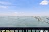 Panoramic water horizon, metal balcony railing, and expansive coastal landscape