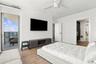 Wood-finish flooring, white ceiling fan, glass-panel balcony door, and built-in walk-in closet shelving