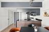 Kitchen featuring matte grey cabinetry, black countertops, wood-finish slat paneling on the island, wood-finish flooring, and multi-pendant lighting