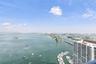High-rise perspective featuring expansive water panoramas, coastal horizon, and a protected marina with deep-water boat slips