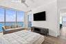 Floor-to-ceiling windows, wood-finish flooring, ceiling fan, and balcony access