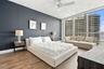 Floor-to-ceiling windows, wood-finish flooring, accent wall, and ceiling-mounted fan